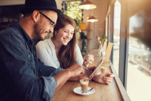 Couple siting in coffee shop using tablet